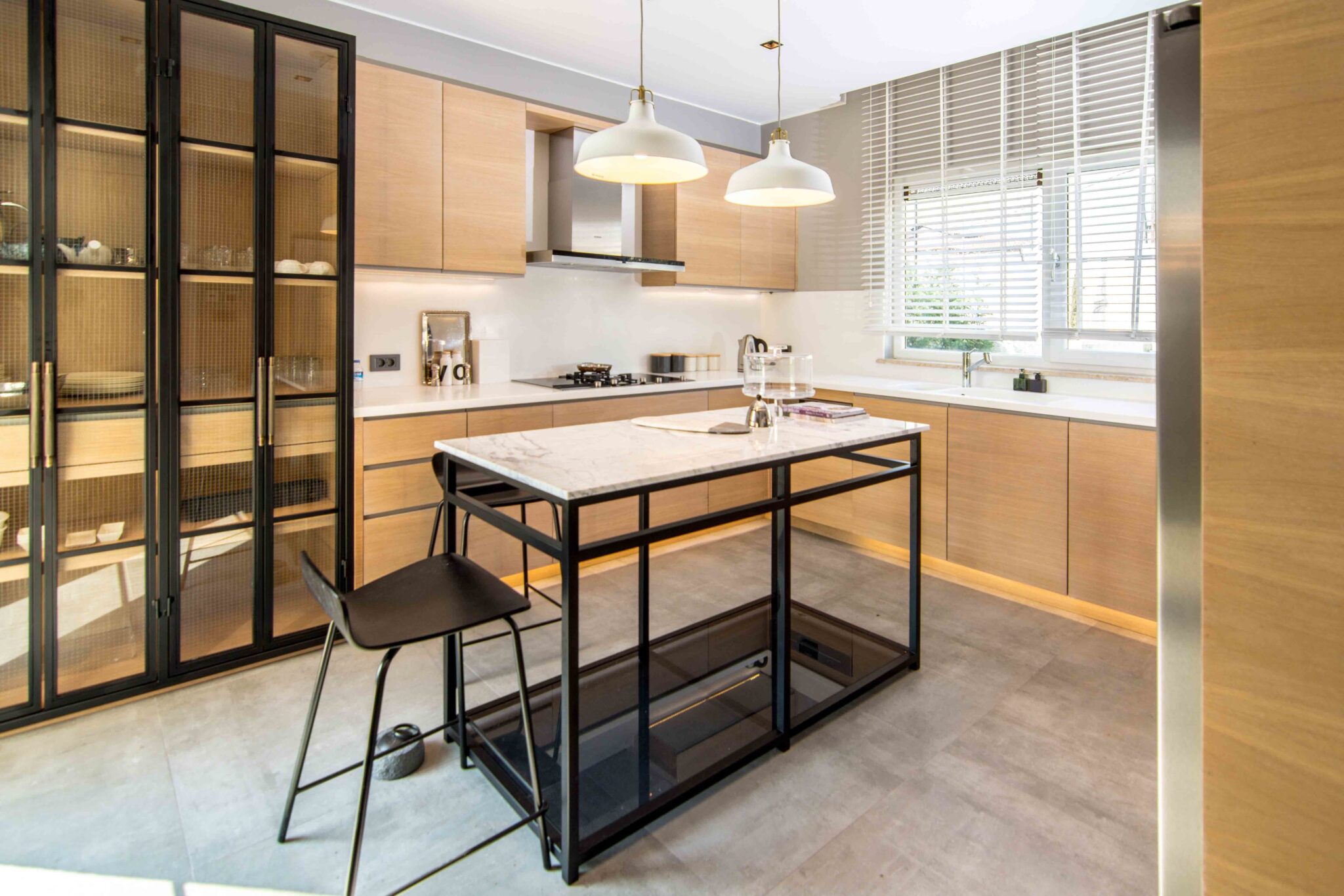 A beautiful shot of the kitchen in a modern apartment with a table with bar chairs